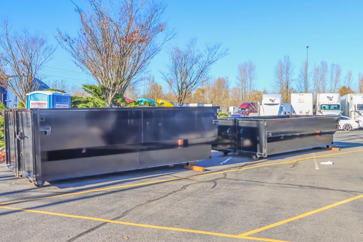 Professional dumpster rental service with roll-off container on residential driveway in Grain Valley